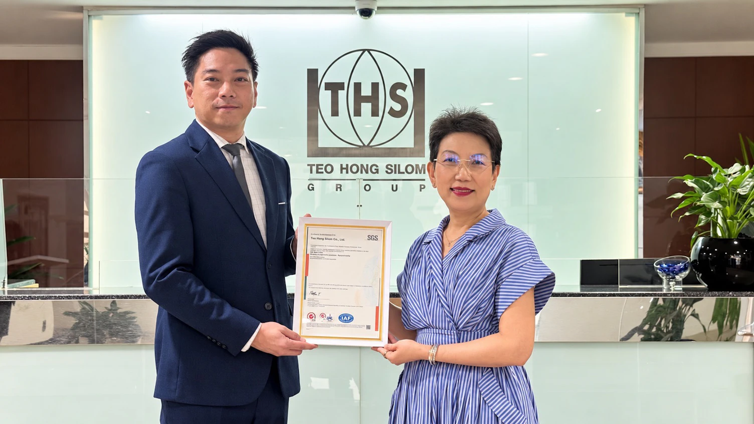 คุณระพีพันธ์ จิวานุวงศ์ จาก SGS มอบใบรับรอง ISO 9001 แก่คุณกัลยกร ศิริรัตน์อัสดร