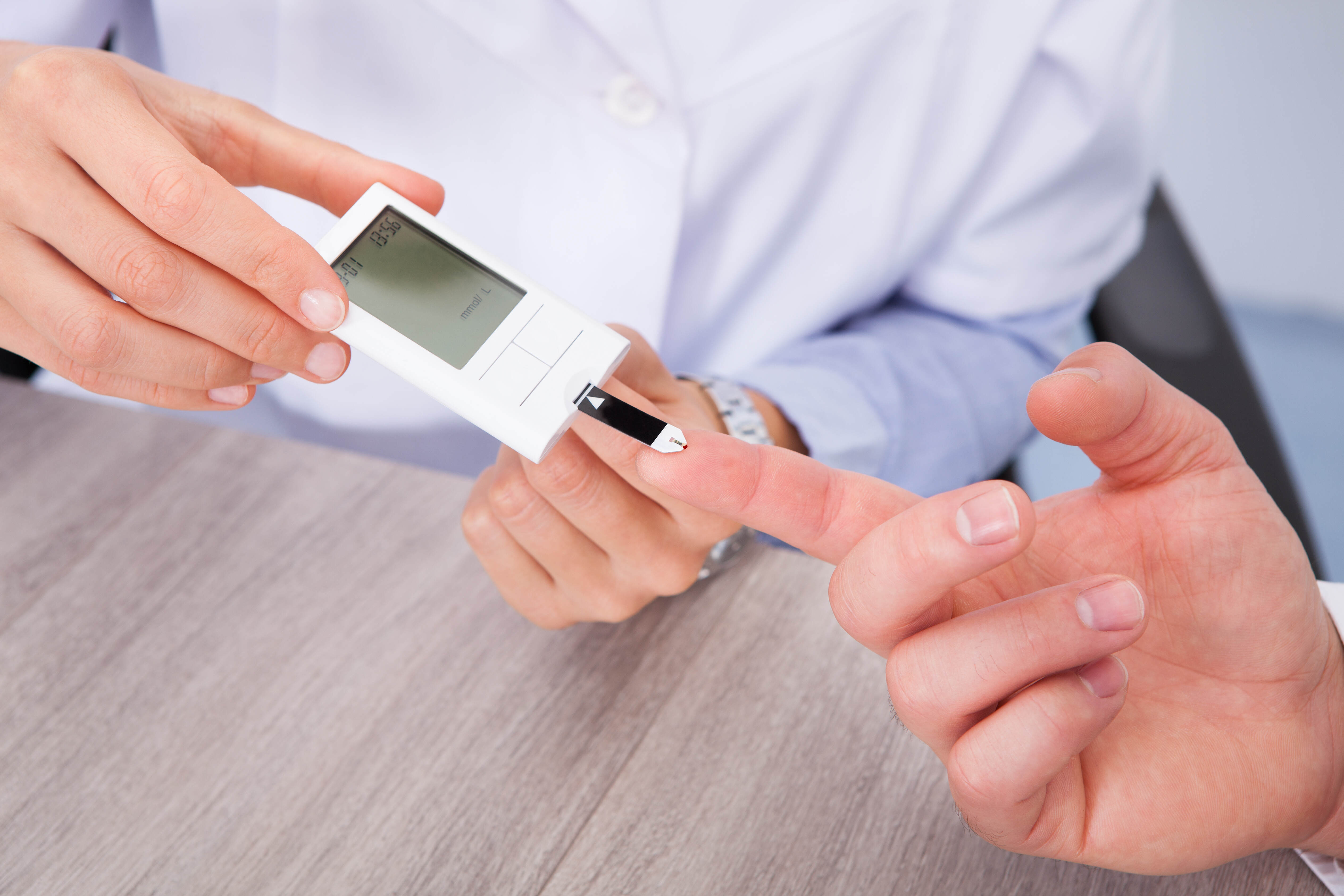 Close-up Of Doctor Holding Patient's Finger Checking Sugar Level
