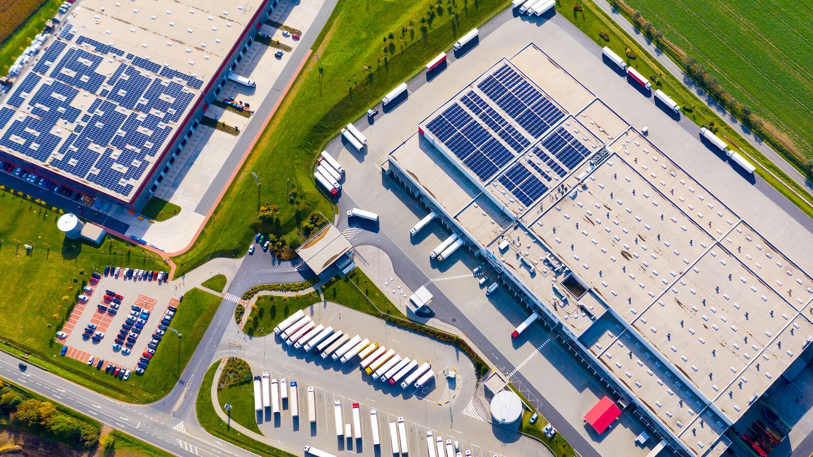 Aerial View of a Warehouse Equipped with Solar Panels
