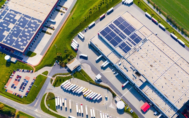 Aerial View of a Warehouse Equipped with Solar Panels