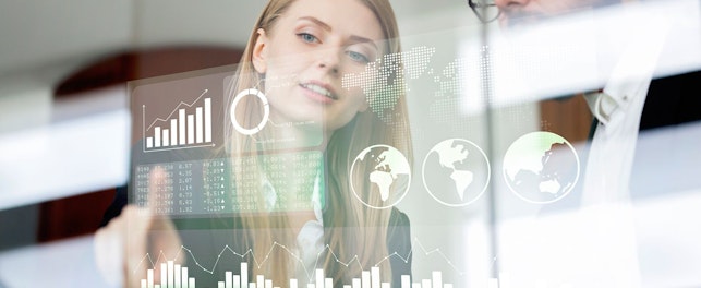 Business colleagues discussing financial data on screen