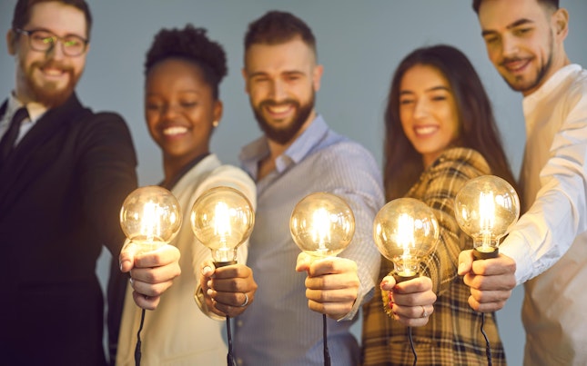 Business Colleagues Holding Shining Light Bulbs