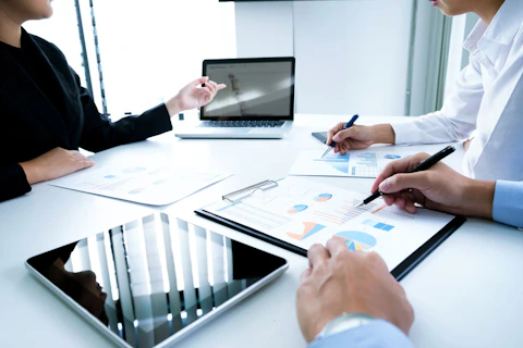 Business People Analyzing Data in Board Room
