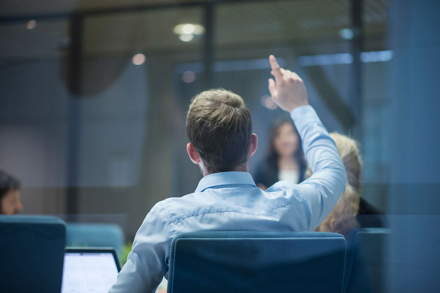 Businessman Raising his Hand During a Presentation