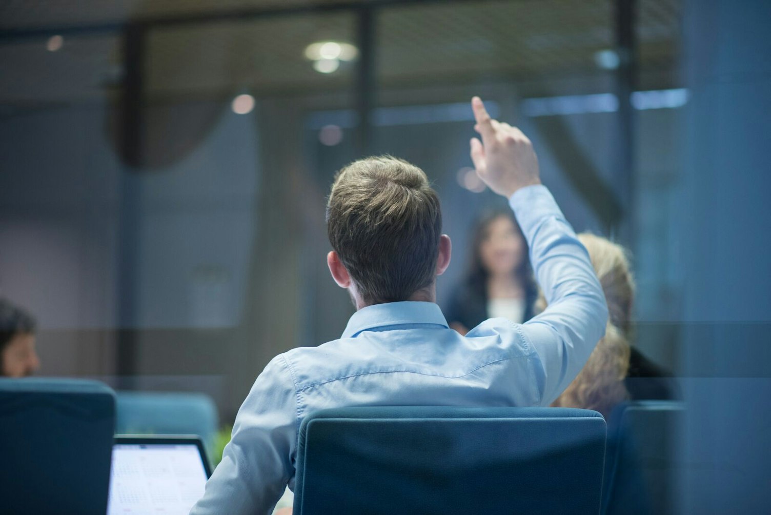Businessman Raising his Hand During a Presentation