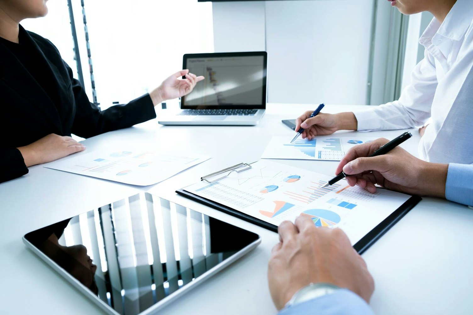 Businesspeople using a laptop to discuss financial data