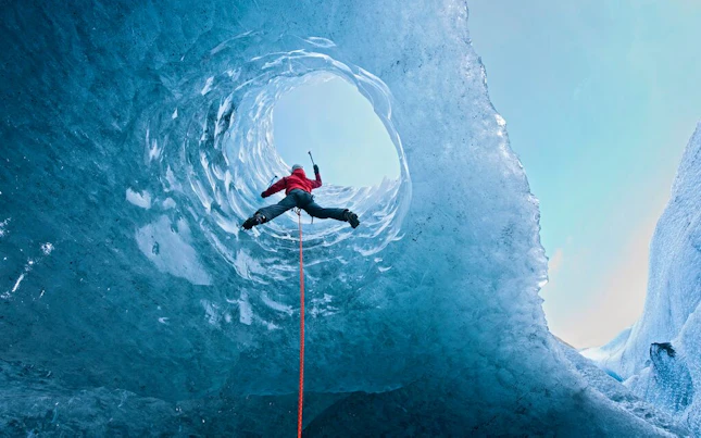 Climber Climbing out of Ice Cave