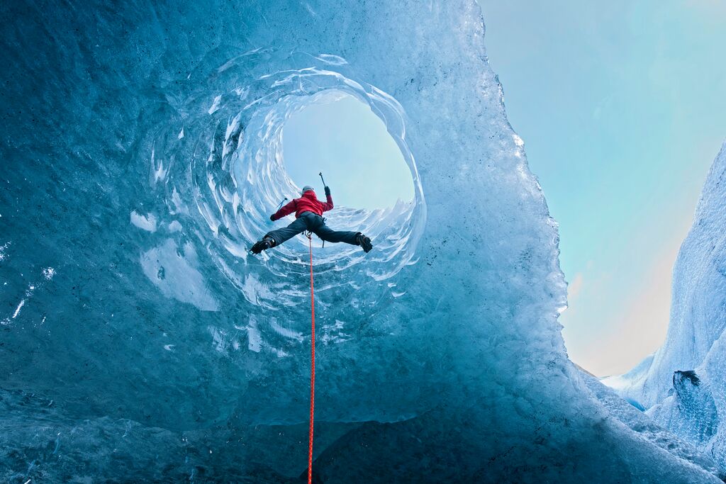 Climber Climbing out of Ice Cave