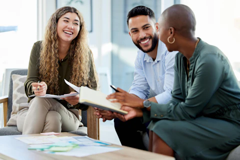 Équipe professionnelle en pleine discussion collaborative dans un environnement de travail lumineux.