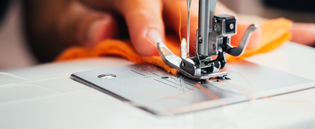 Main d'une femme utilisant une machine à coudre