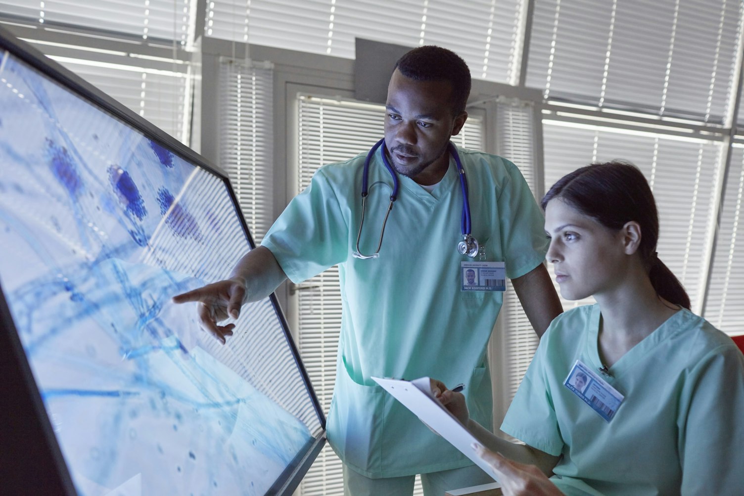 Doctors Examining Magnifying Microscope