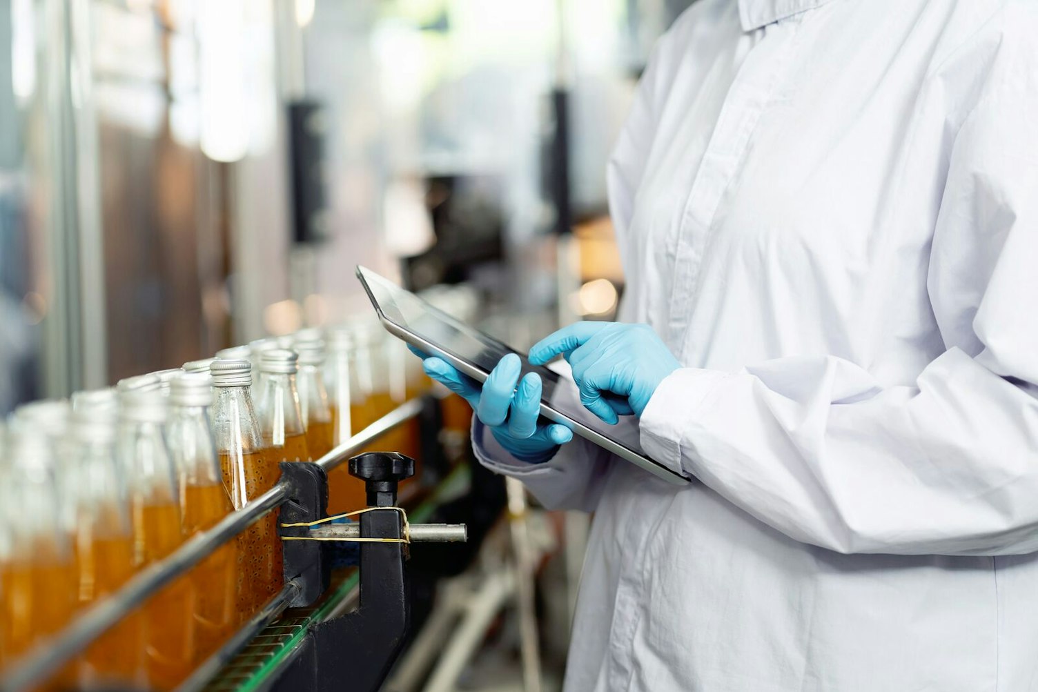 Inspector Checking Bottles on a Conveyor Belt in Beverage Factory