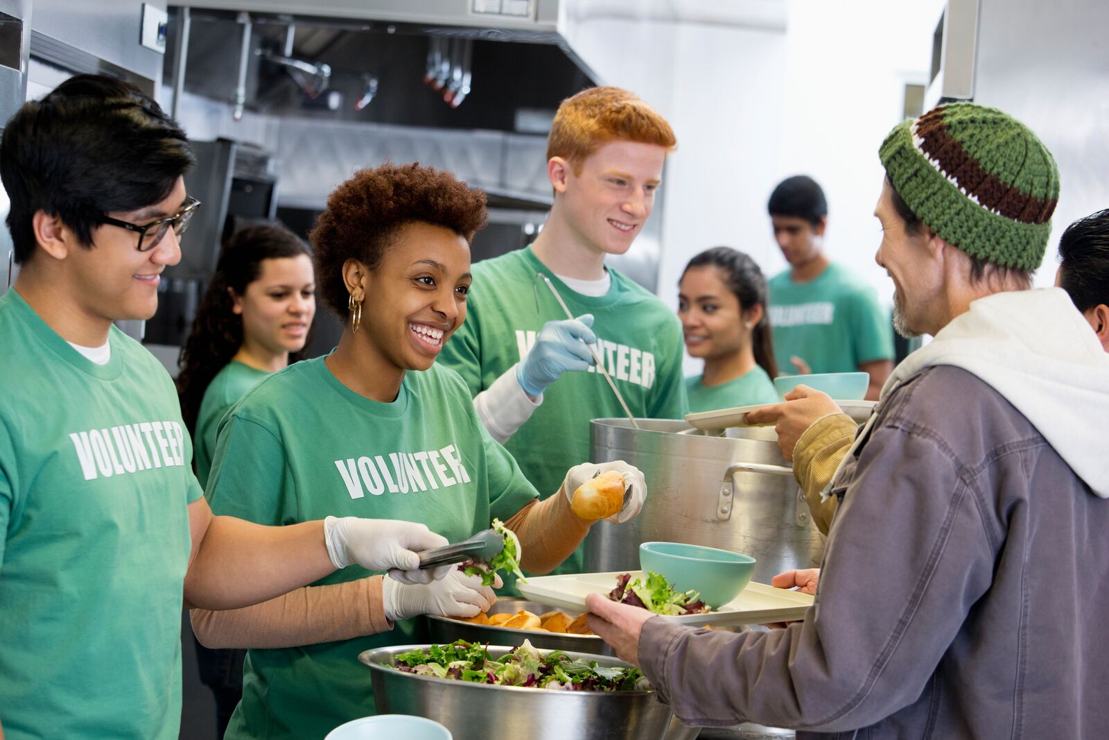 A group of volunteers serving soup and salad to the community.
