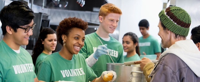 A group of volunteers serving soup and salad to the community.