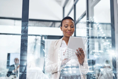 Lady Holding Tablet in Meeting Room in Front of Window
