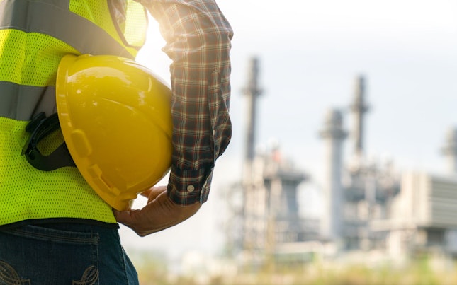 Mid Section of a Worker Holding his Safety Helmet