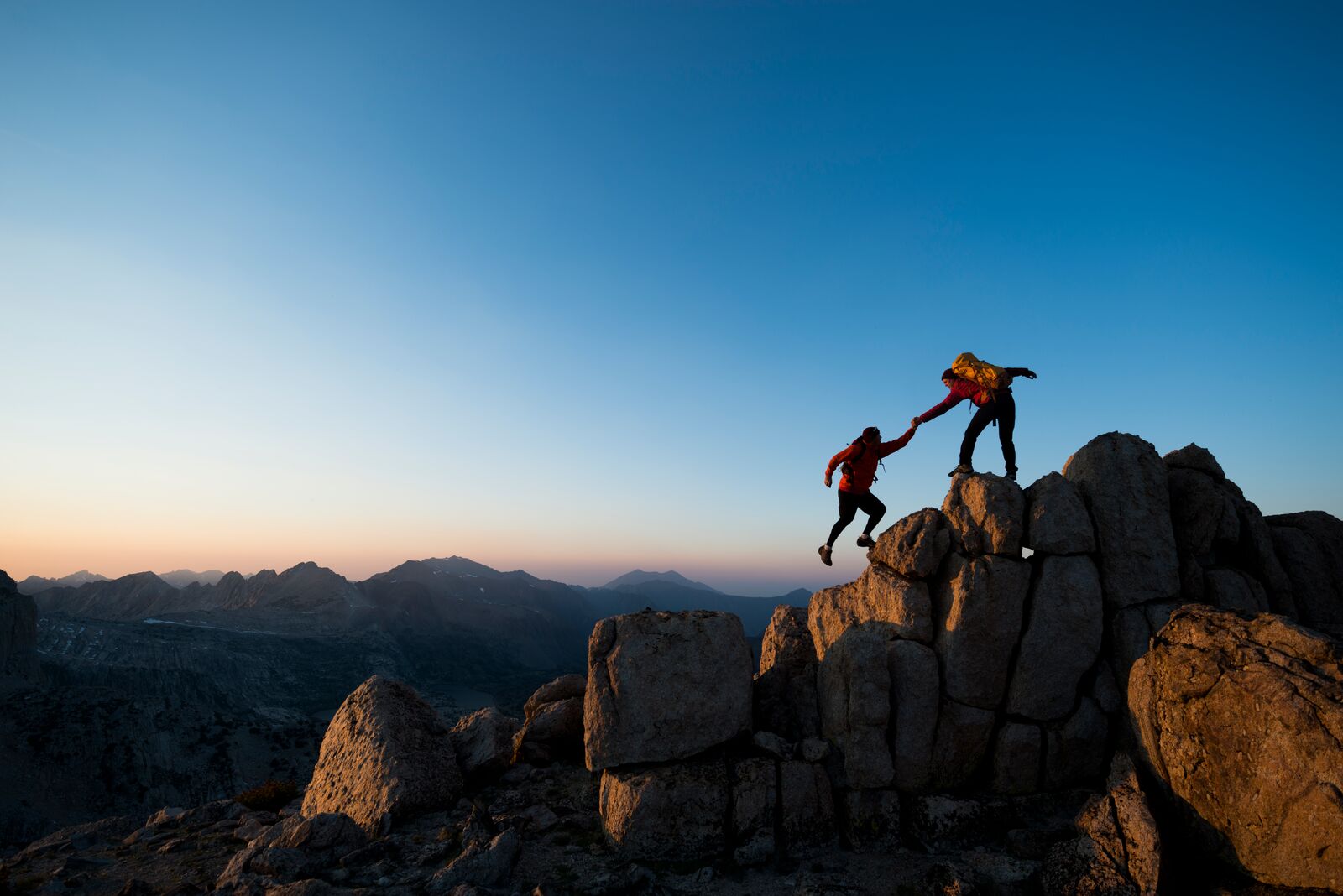 One Climber Helping the Other to Get to the top of a Mountain