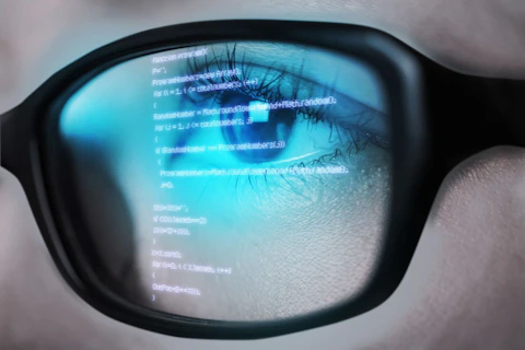 Programming Code of Computer Monitor Reflecting in Woman's Eyeglasses