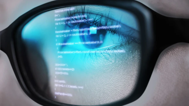 Programming Code of Computer Monitor Reflecting in Woman's Eyeglasses