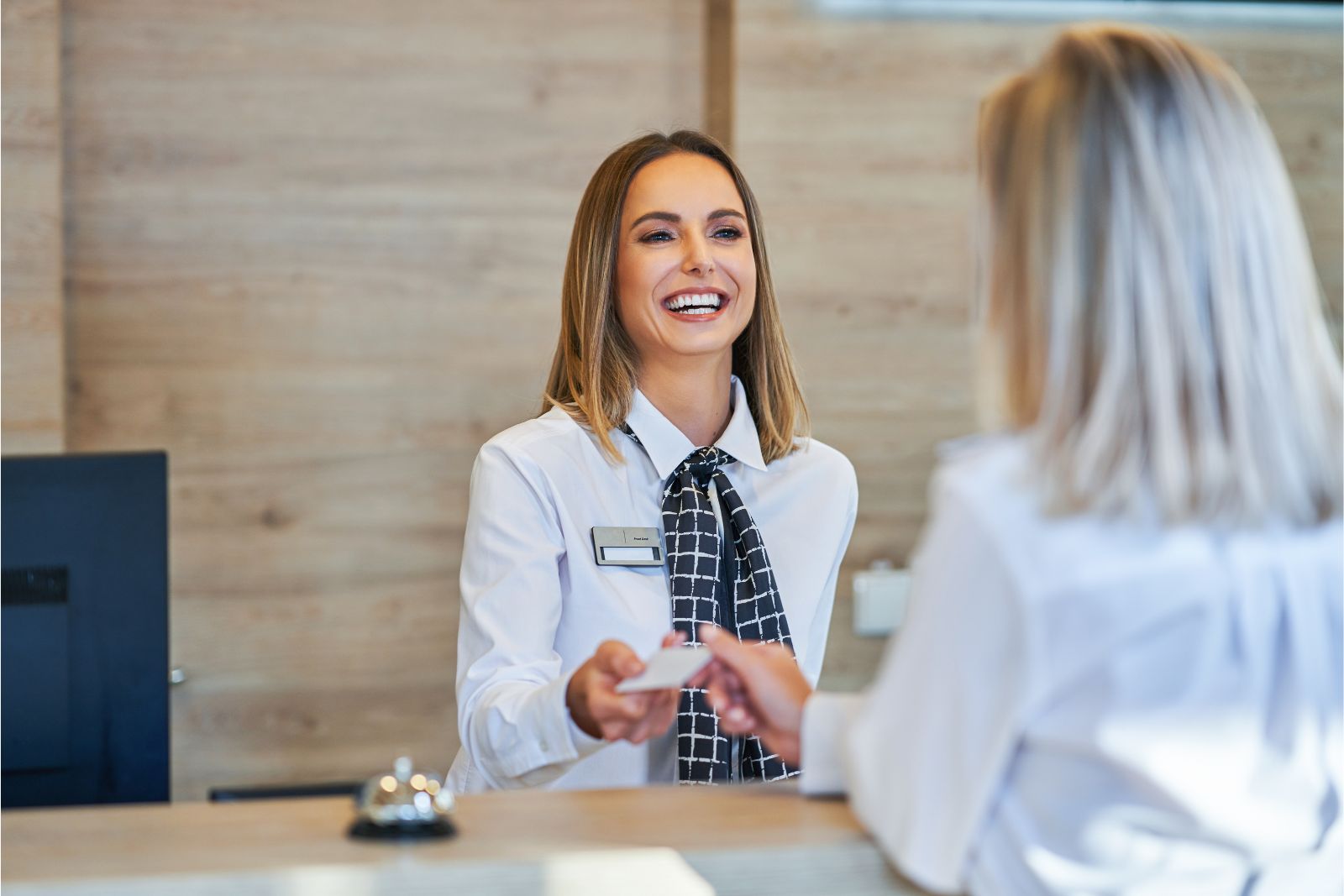 Receptionist at a Hotel Front Desk Helping Customers