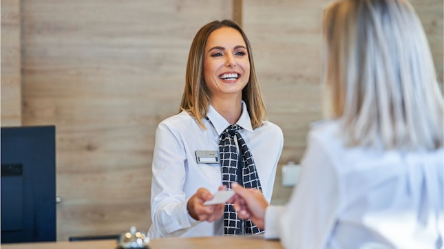 Receptionist at a Hotel Front Desk Helping Customers
