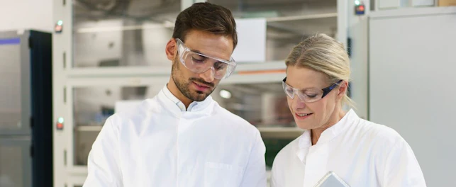 Scientists Discussing in Laboratory Using Digital Tablet