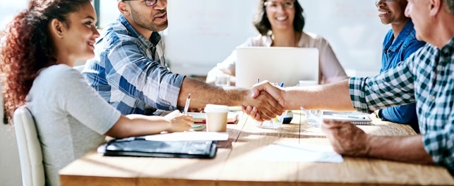 Réunion d’équipe avec poignée de main entre deux collaborateurs