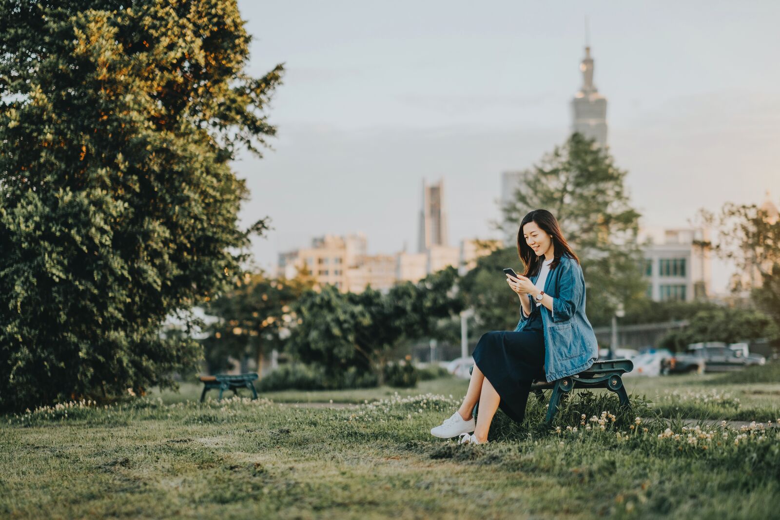 Woman Sitting on a Bench in a Park