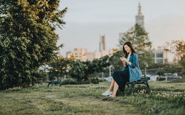 Woman Sitting on a Bench in a Park