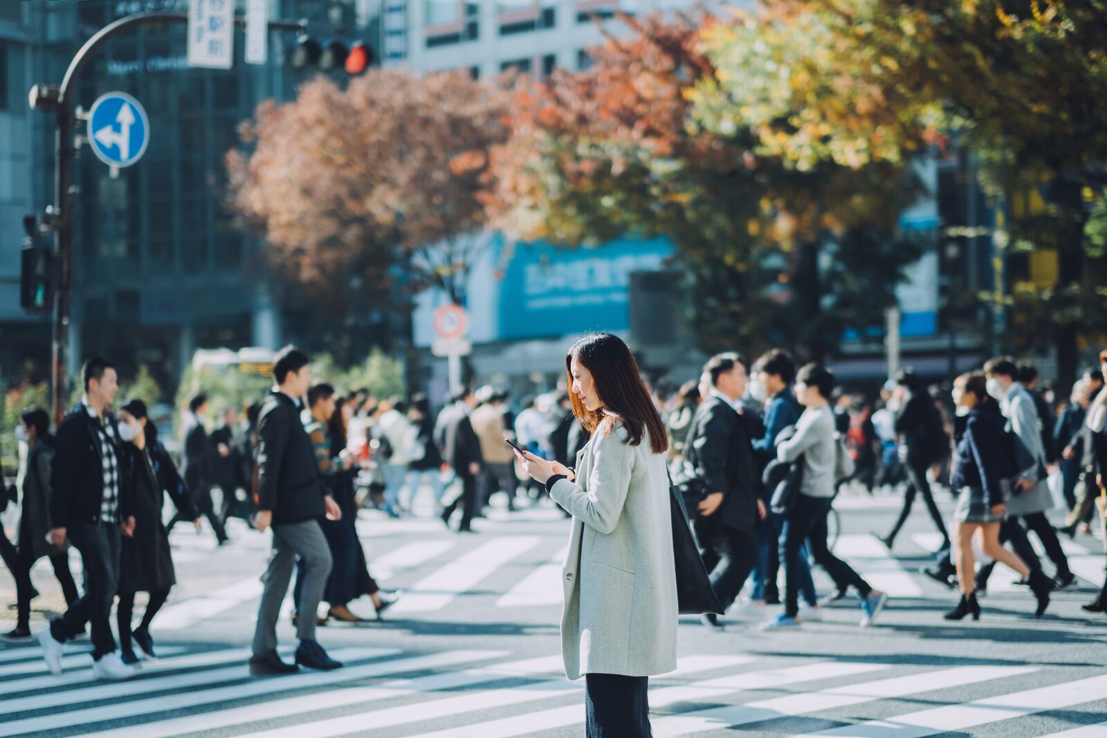 Woman Standing in a Crowd Looking at her Phone