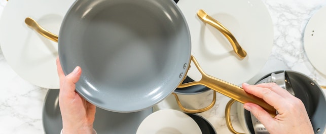 A hand holds up a gray nonstick ceramic frying pan