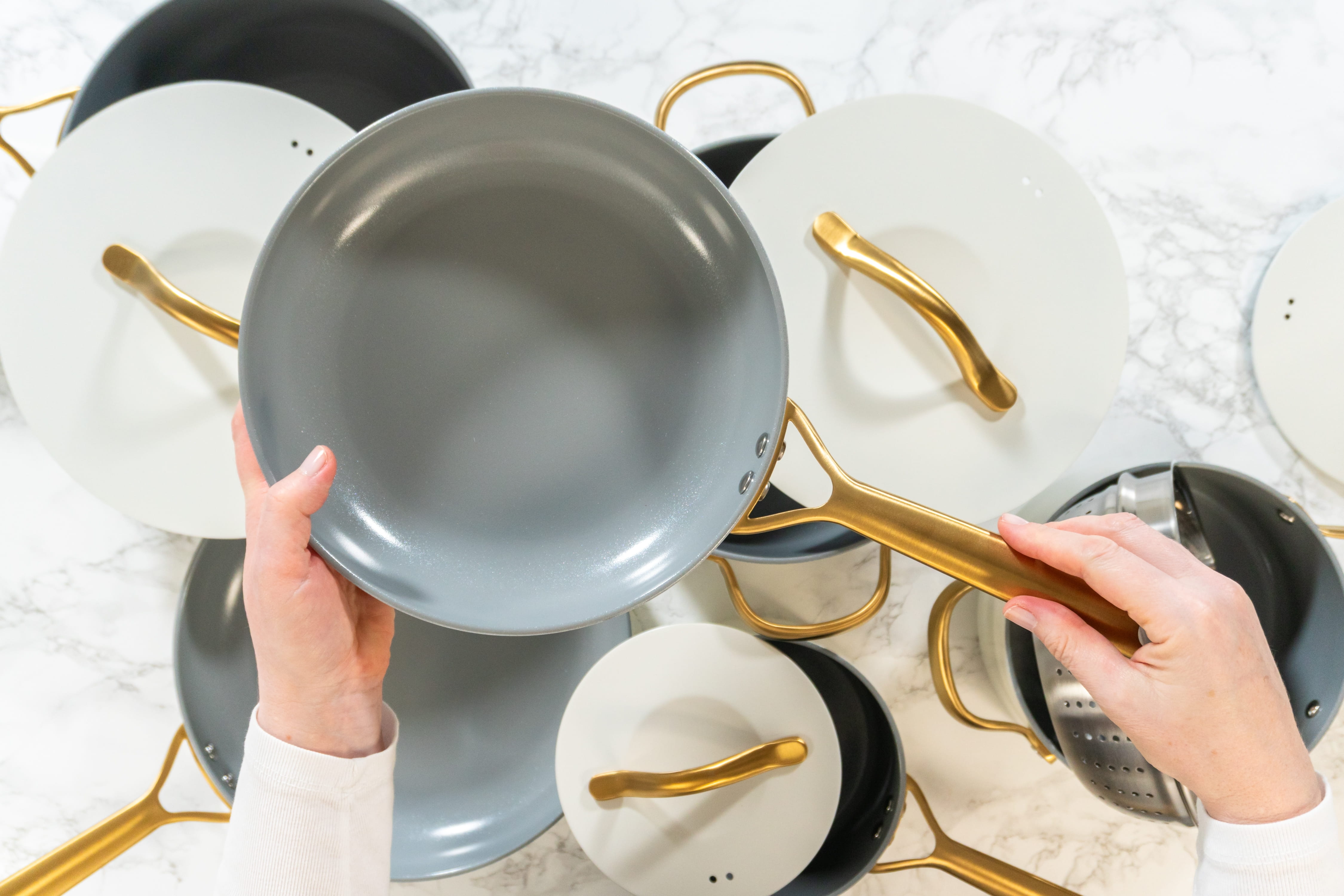 A hand holds up a gray nonstick ceramic frying pan
