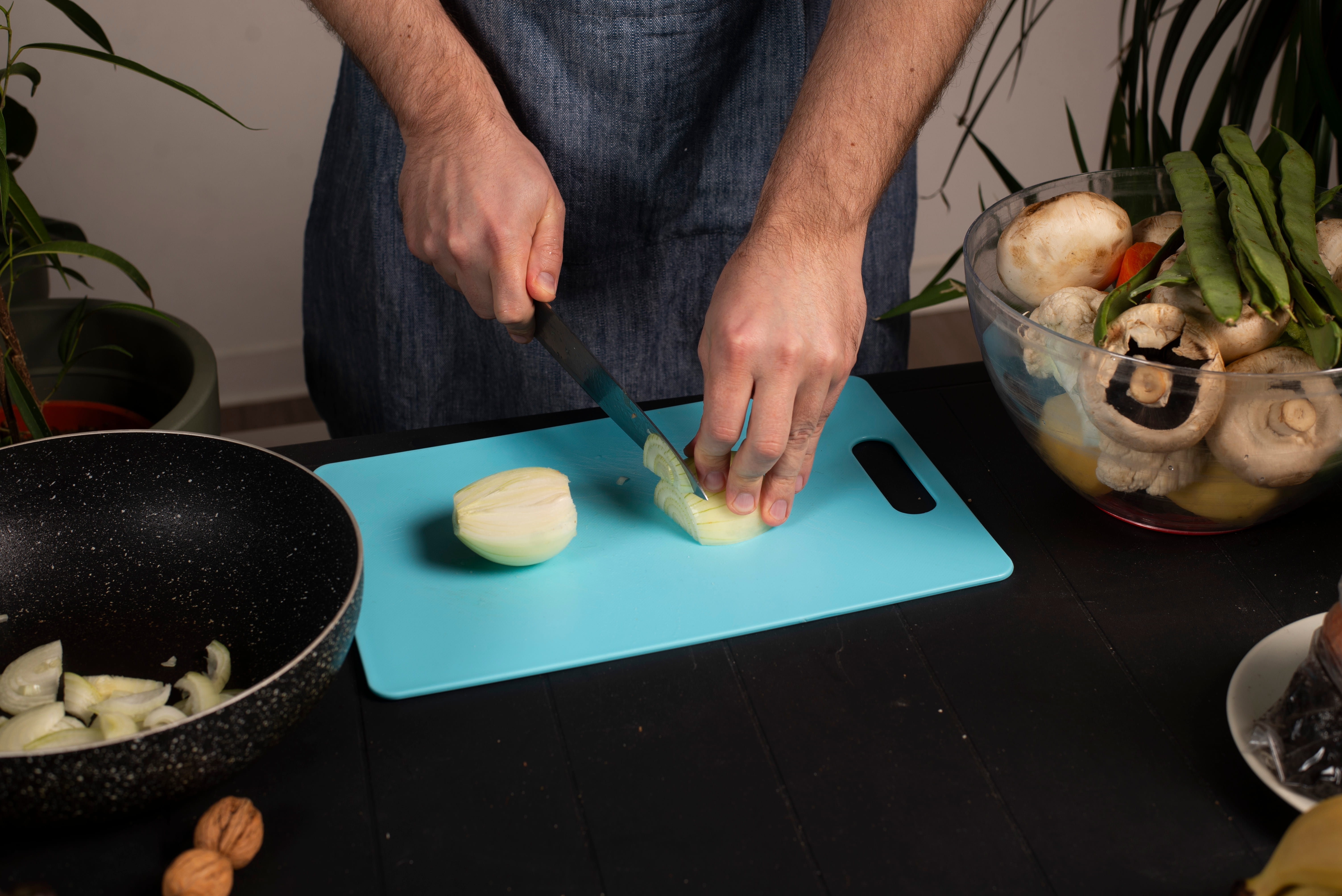 A man is cutting onions on a cutting board