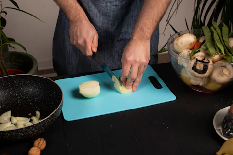 A man is cutting onions on a cutting board