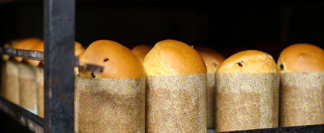 A rack of bread loaves with a paper wrapper