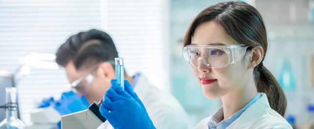 asian female scientist hold a test tube filled with liquid in the laboratory