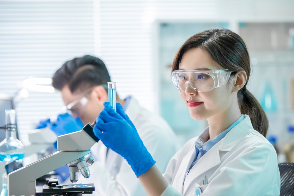 asian female scientist hold a test tube filled with liquid in the laboratory