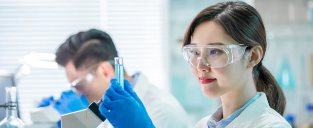 asian female scientist hold a test tube filled with liquid in the laboratory