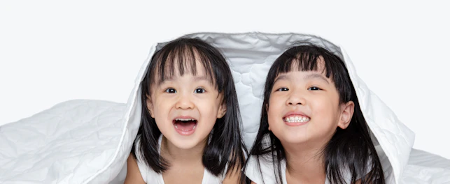 Asian little Chinese girls playing on the bed