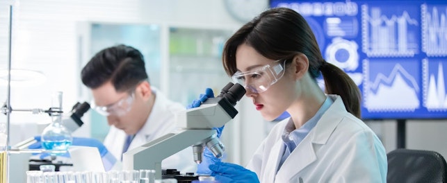 Asian Scientist Team Use Microscope in the Laboratory