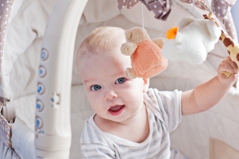 Baby Boy Playing Sitting in the Cradle with Mobile Toy Giraffe