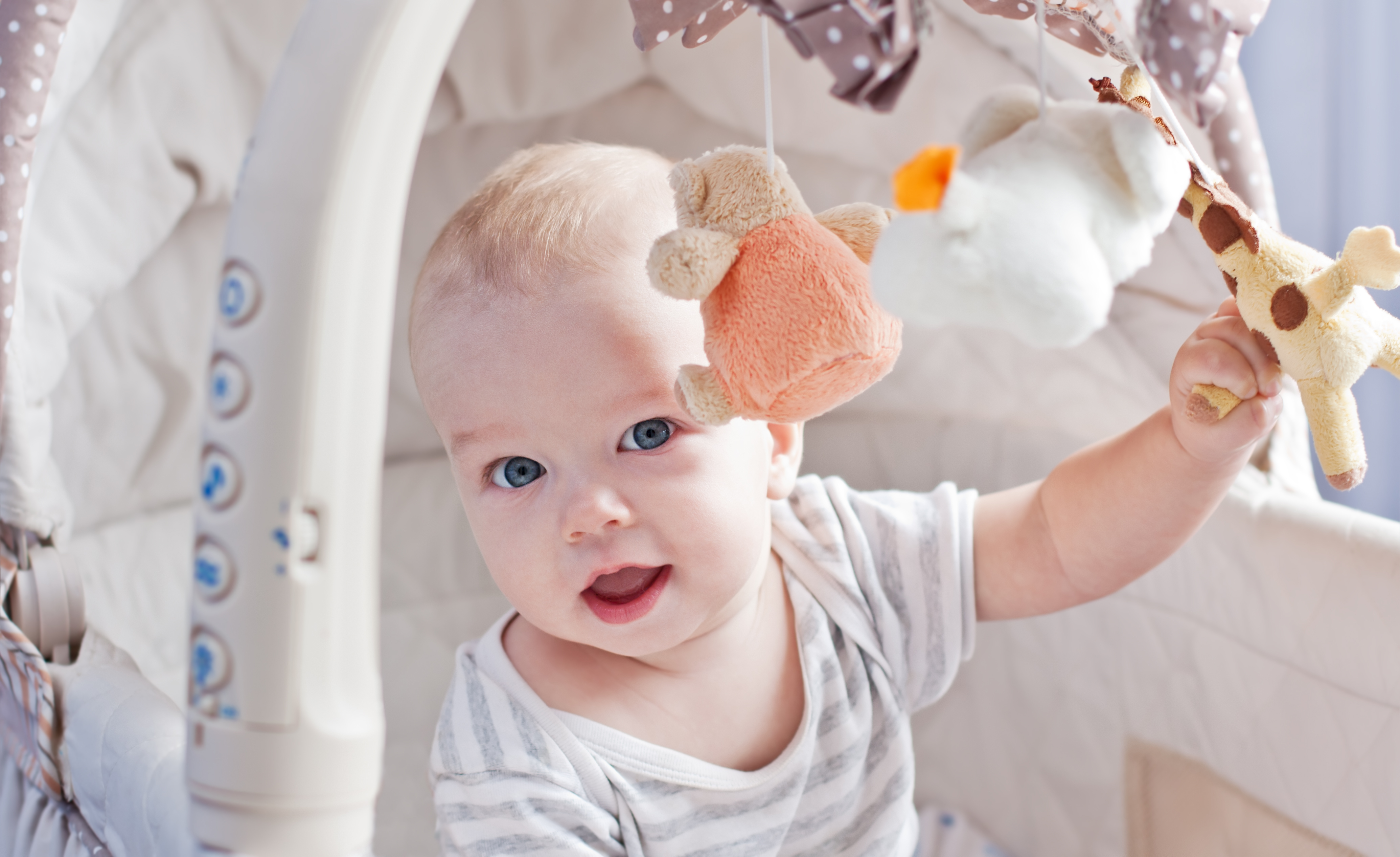 Baby Boy Playing Sitting in the Cradle with Mobile Toy Giraffe