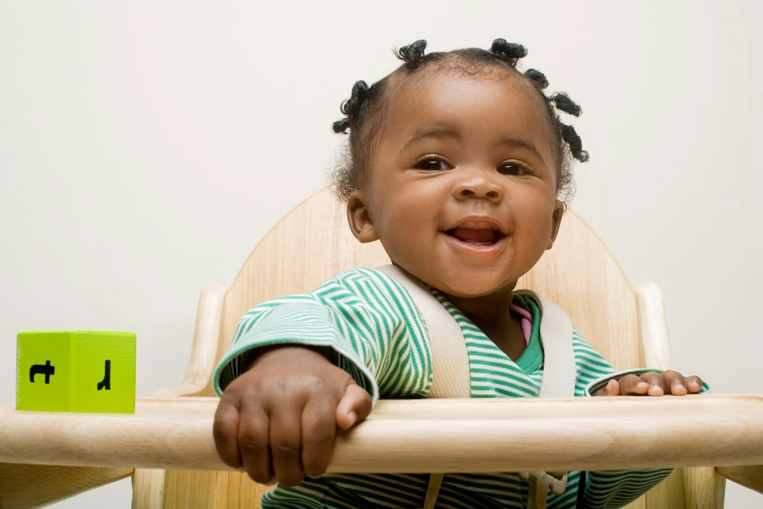 Baby Girl Strapped in a High Chair