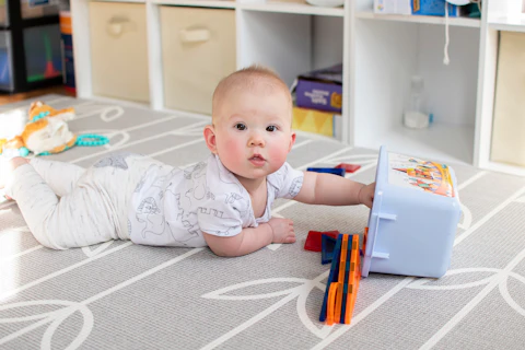 Baby laying on tummy playing with toys