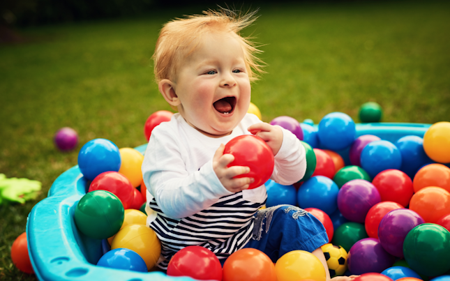 Baby Playing in Pool Filled with Colourful Plastic Balls