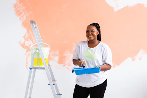 Beautiful african american girl painting the wall