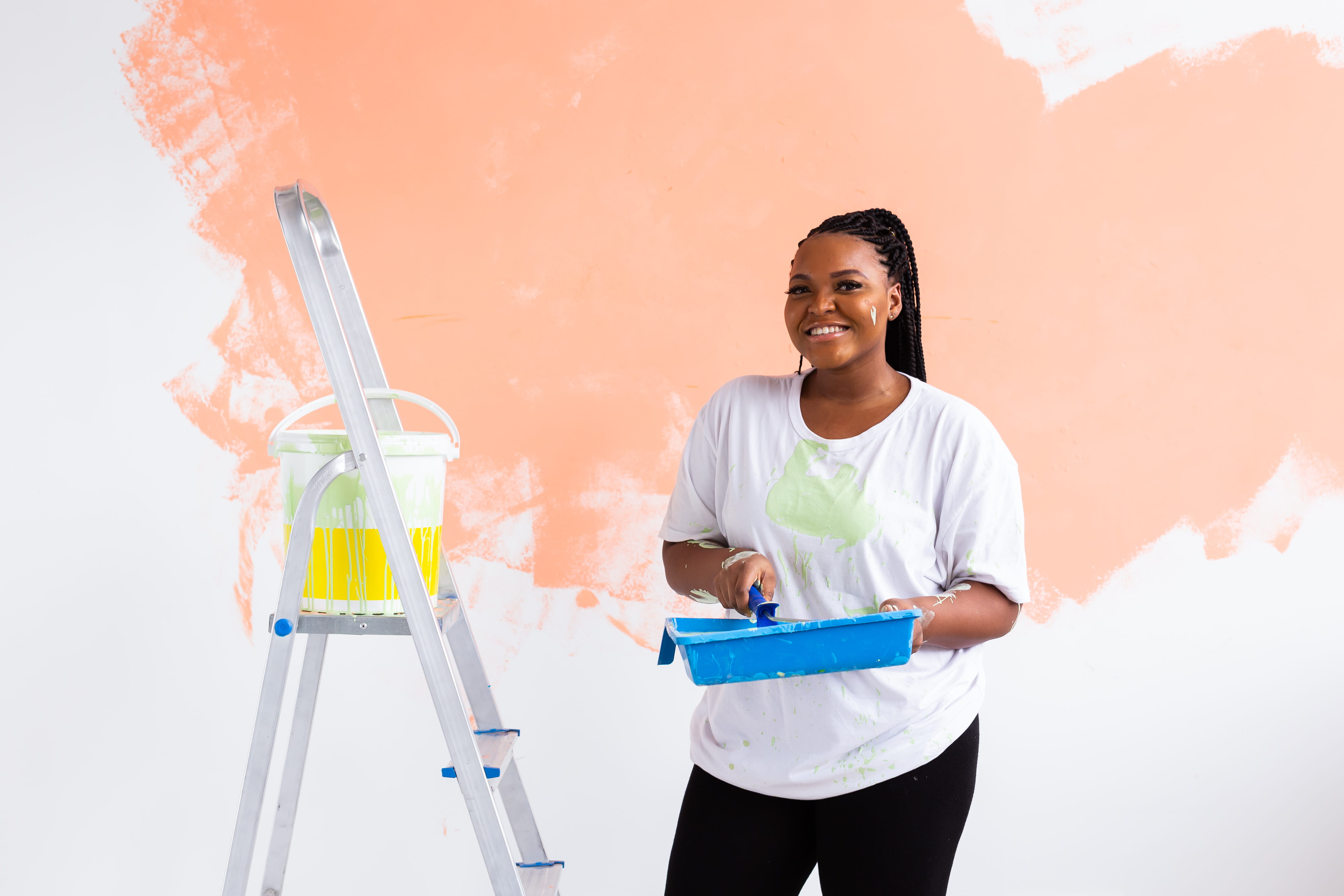Beautiful african american girl painting the wall