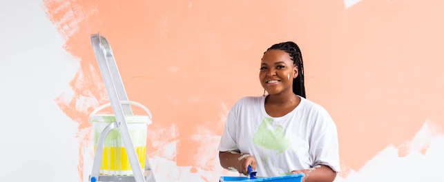 Beautiful african american girl painting the wall