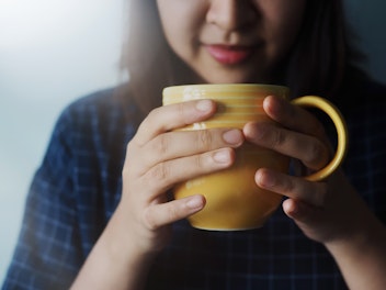 Beautiful Woman Drinking Lemon Ginger Tea in the Morning or Cold Season