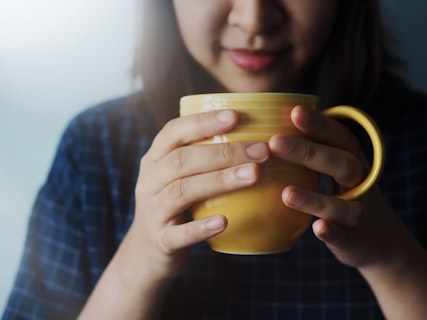 Beautiful Woman Drinking Lemon Ginger Tea in the Morning or Cold Season